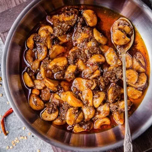 Authentic lahsun ka aachar with whole garlic cloves pickled in mustard oil and spices